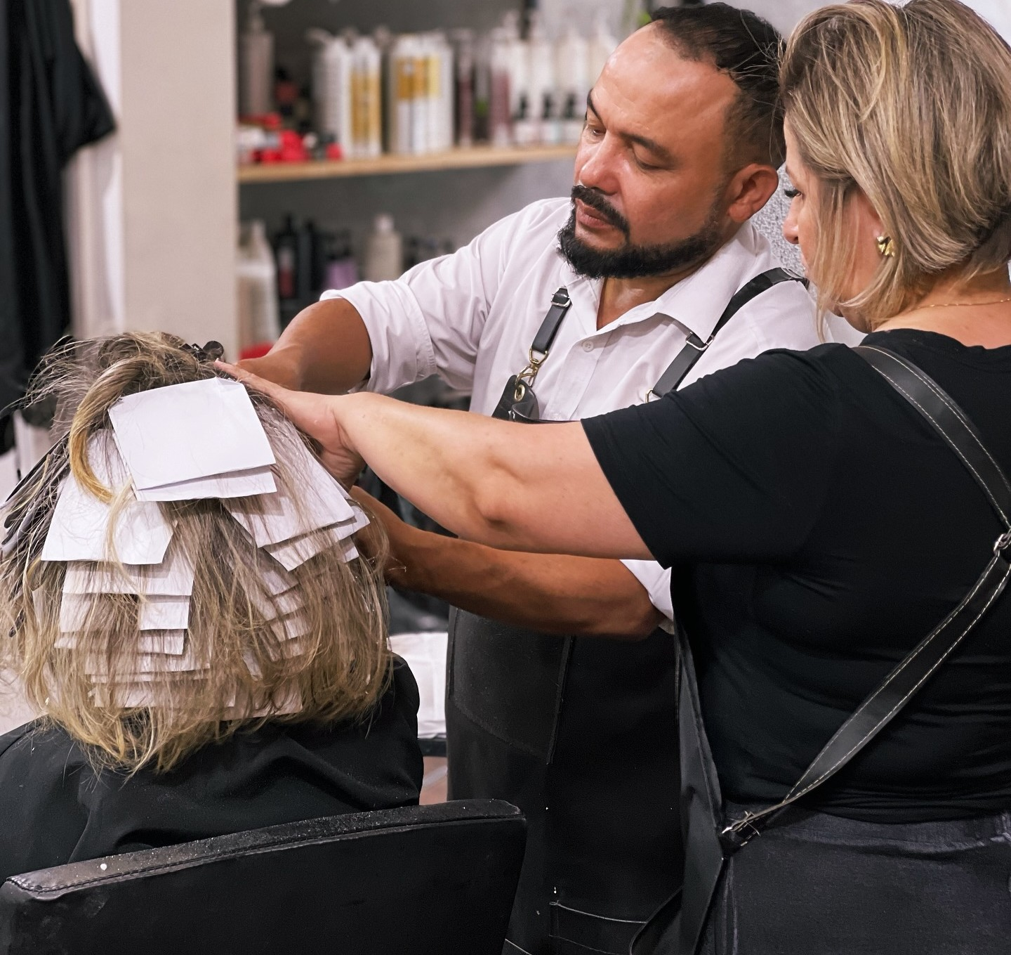 Paulinho e Cris aplicando mechas em uma cliente no salão